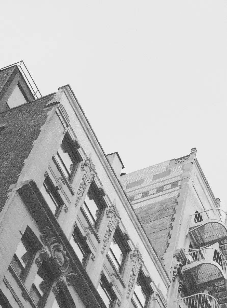 Black and white photo looking up at NYC multifamily buildings